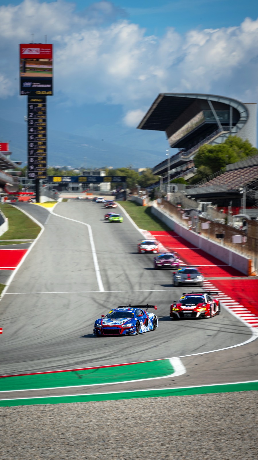 The Audi leading a GT pack through the stadium section at Circuit de Barcelona‑Catalunya.