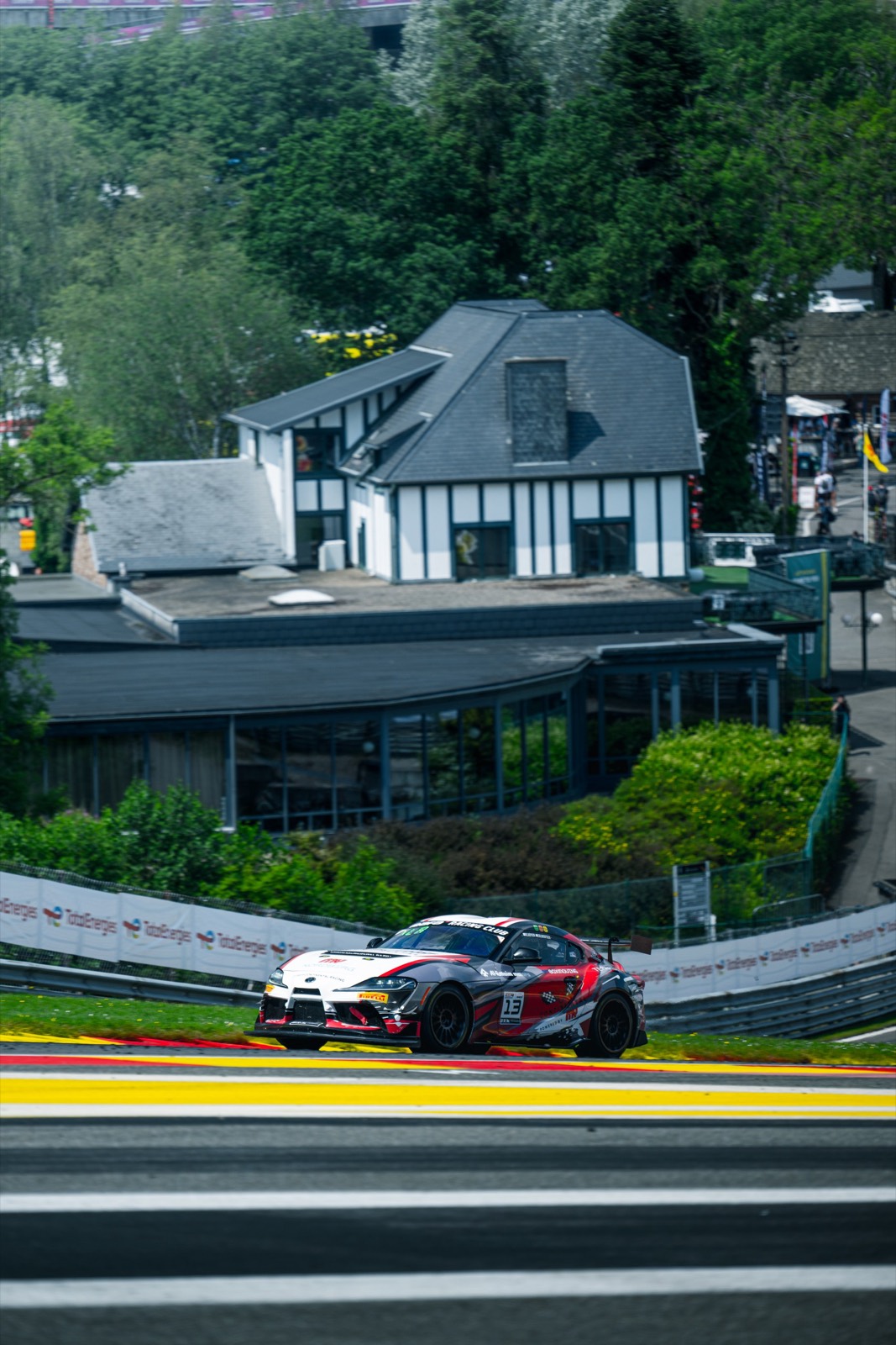 The Supra GT4, number 13, climbing the hill at Spa‑Francorchamps.