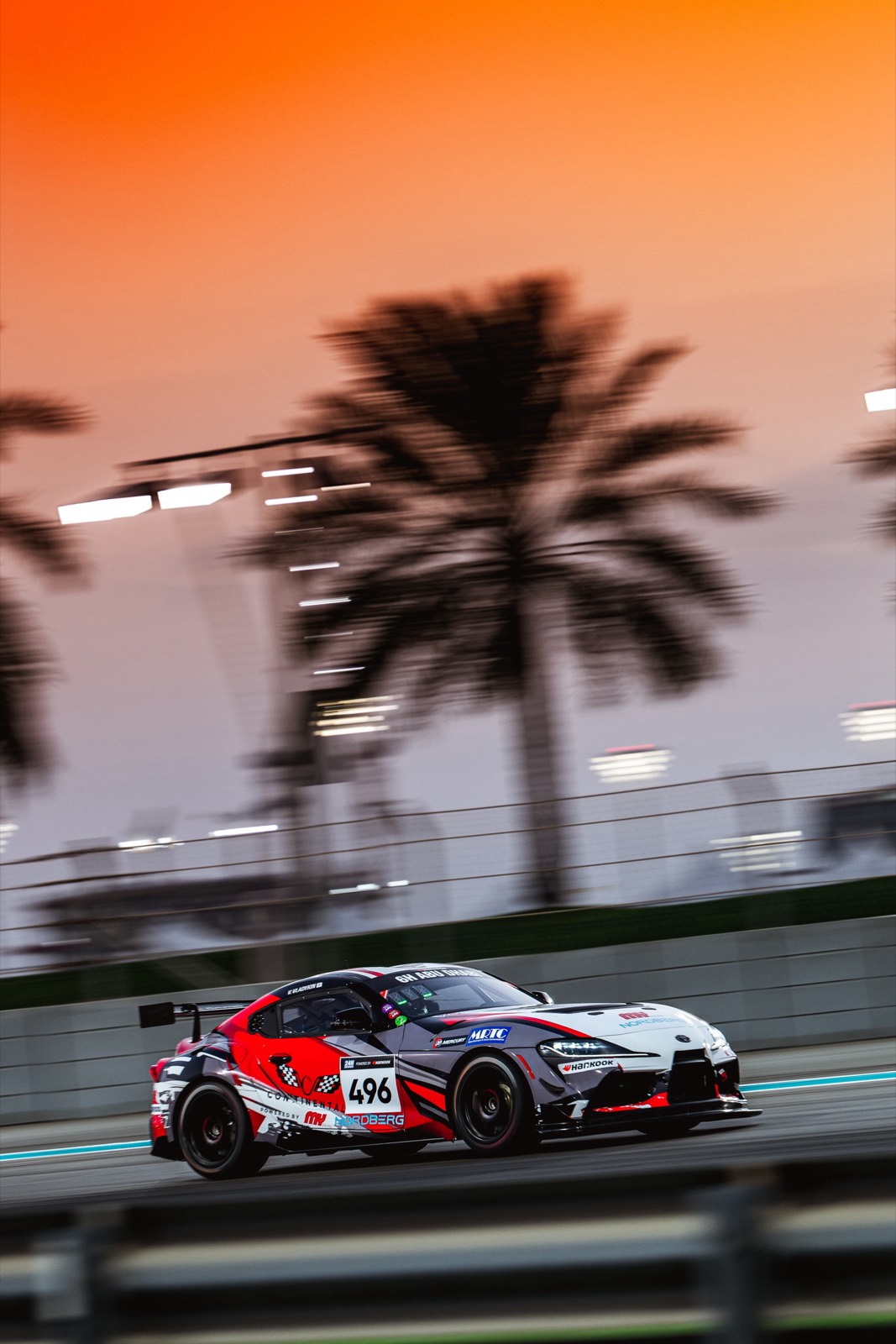 The Toyota GR Supra GT4, number 496, at dusk under the palms at Yas Marina.