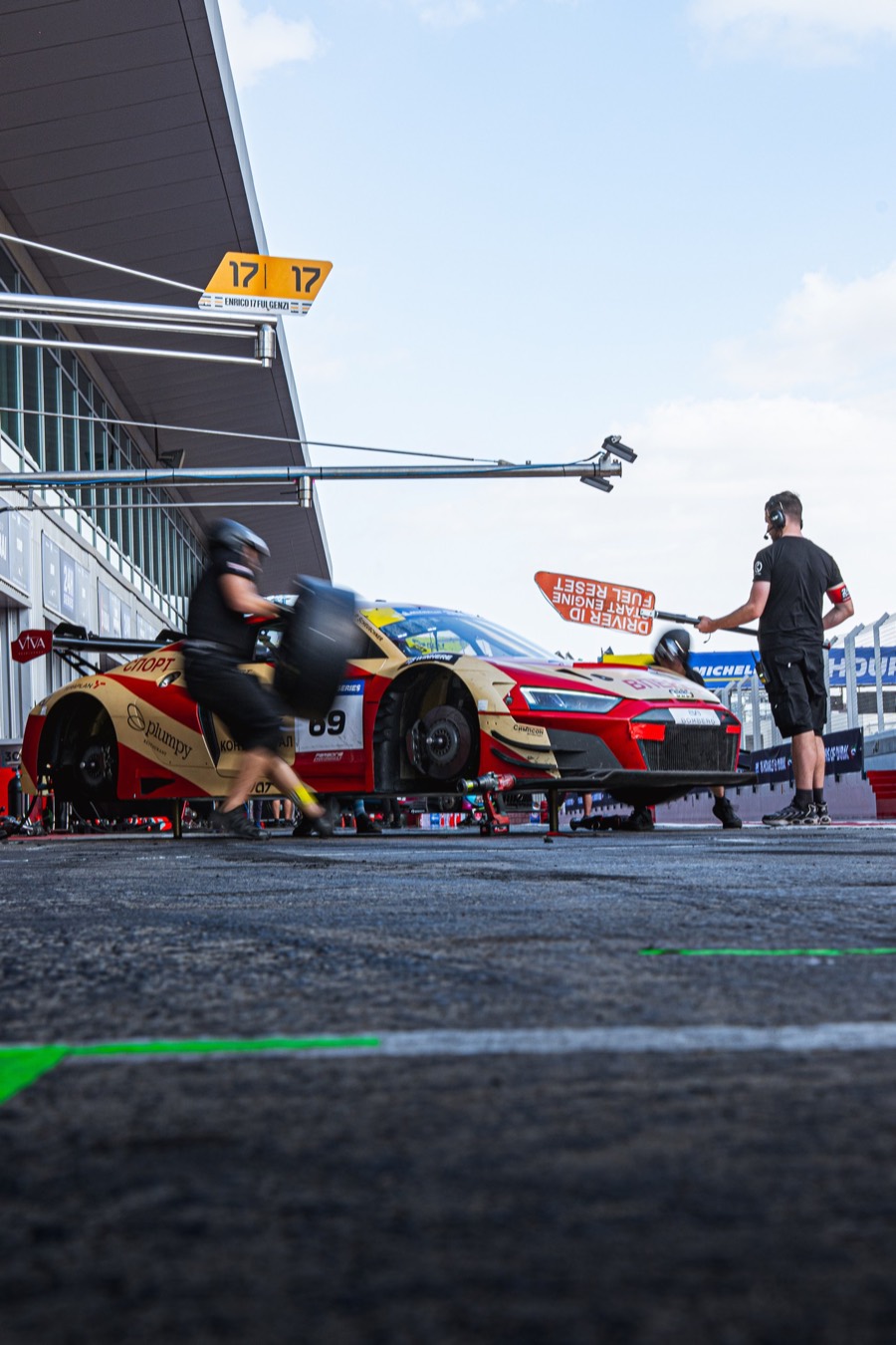 The number 69 Audi on its jacks in the pit lane, a wheel on the way, Dubai 24 Hour 2026