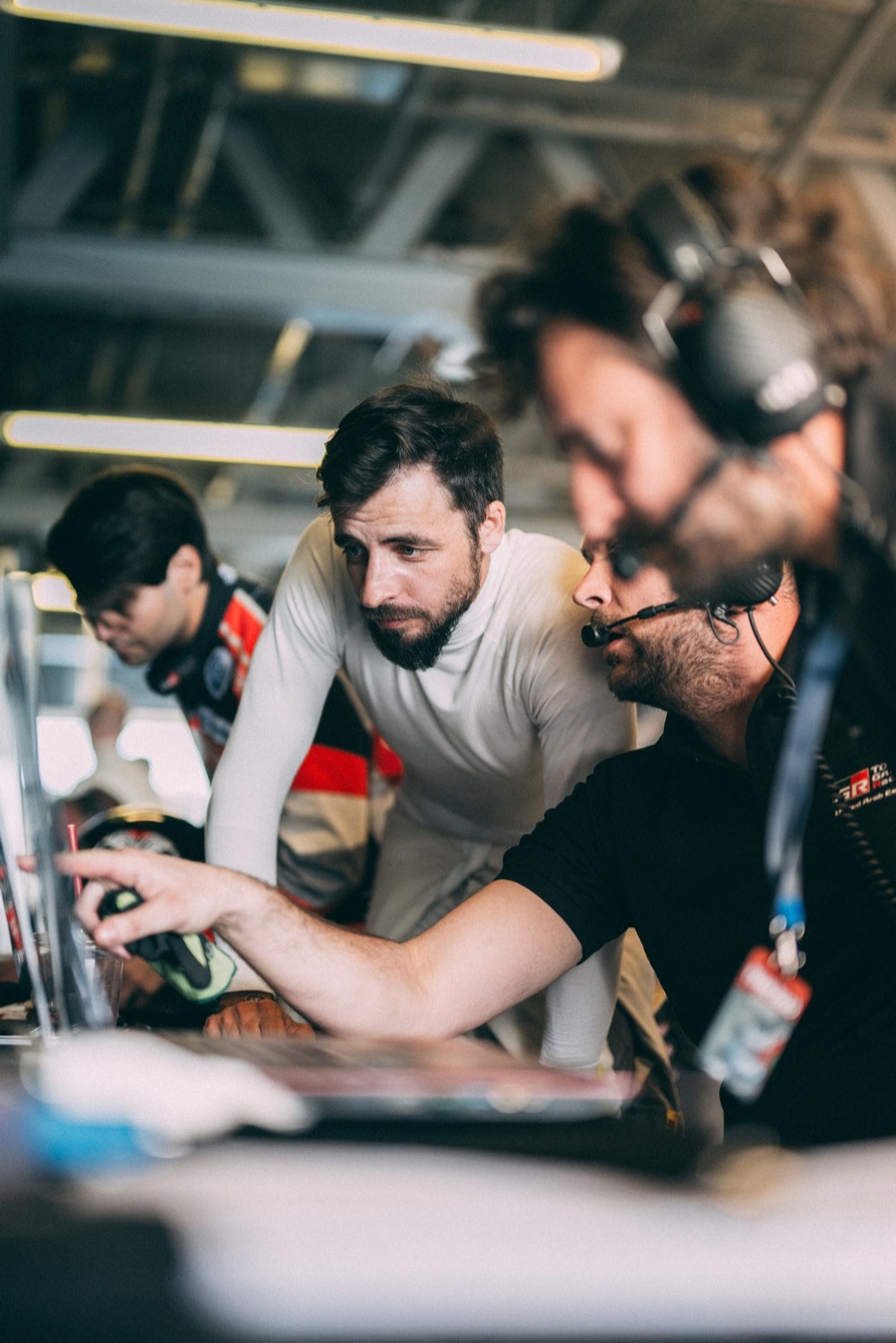 Three of the crew bent over the laptops at the pit desk during the 24 Hours of Dubai