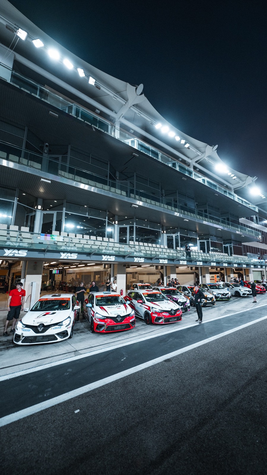The Clio Cup cars lined up along the pit lane under the Yas Marina lights at night